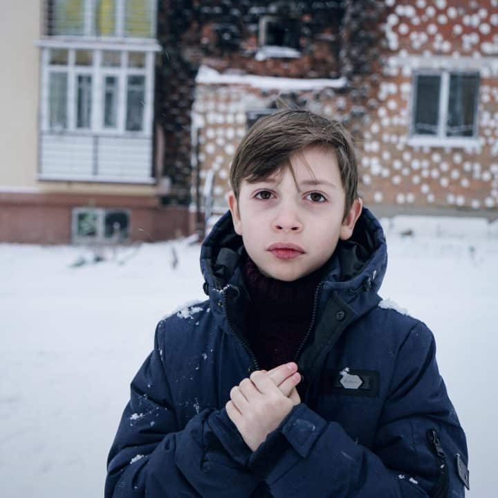 Le 14 décembre 2022, Zhenya, 7 ans, pose pour une photo devant sa maison à Irpin, dans la région de Kiev, en Ukraine. © UNICEF/UN0760448/Hrom