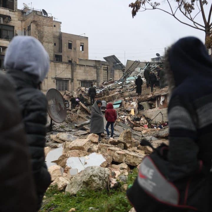 Le 6 février 2023, des personnes se rassemblent autour de bâtiments effondrés tandis que les équipes de secours cherchent des survivants après un tremblement de terre dans la ville syrienne d'Alep. © UNICEF/UN0777950/AFP