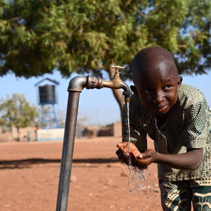 Un garçon boit de l'eau dans la cour de récréation de son école AMITIE A, à Dedougou, dans l'ouest du Burkina Faso. ©UNICEF/UN0753031/Dejongh