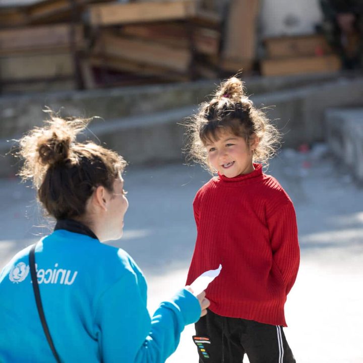 Le 20 février 2023, Naya, une fillette de quatre ans, montre son dessin à un membre du personnel de l'UNICEF lors d'une activité artistique dans un abri du village de Stamo, en Syrie. Naya a fui sa maison à cause du tremblement de terre et utilise le dessin pour exprimer ses émotions. ©UNICEF/UN0792084/Haddad