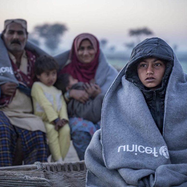 Sameer, 8 ans, et sa famille, assis en extérieur sur un charpoy après avoir reçu un kit d'hiver de l'UNICEF dans le village de Zangi Brohi, District de Dadu, Sindh. © UNICEF/UN0761226/Butt