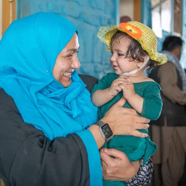 Le 26 juin 2023, Fouzia Shafique, conseillère principale en santé de l'UNICEF Afghanistan, interagit avec une petite fille dans un hôpital soutenu par l'UNICEF dans la province de Kunar, en Afghanistan. © UNICEF/UNI404855/Karimi