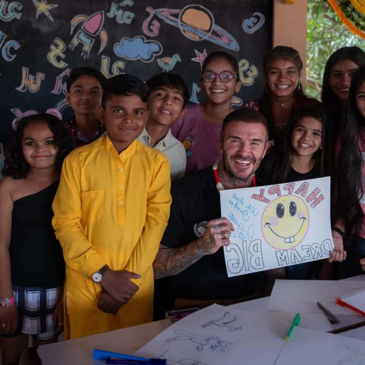 Le 14 novembre 2023 en Inde, l'ambassadeur de bonne volonté de l'UNICEF David Beckham présente un dessin qu'il a réalisé lors d'une discussion avec un groupe d'adolescents au centre communautaire du district de Banaskantha, dans l'État du Gujarat. ©UNICEF/UNI471347/Mukherjee