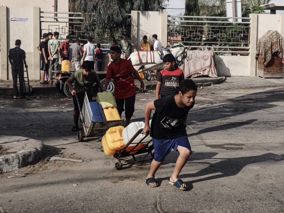 Des enfants vont chercher de l'eau dans la ville de Khan Younis, au sud de la bande de Gaza. Les systèmes d'approvisionnement en eau de la bande de Gaza sont fortement endommagés et non opérationnels. © UNICEF/UNI463122/El Baba
