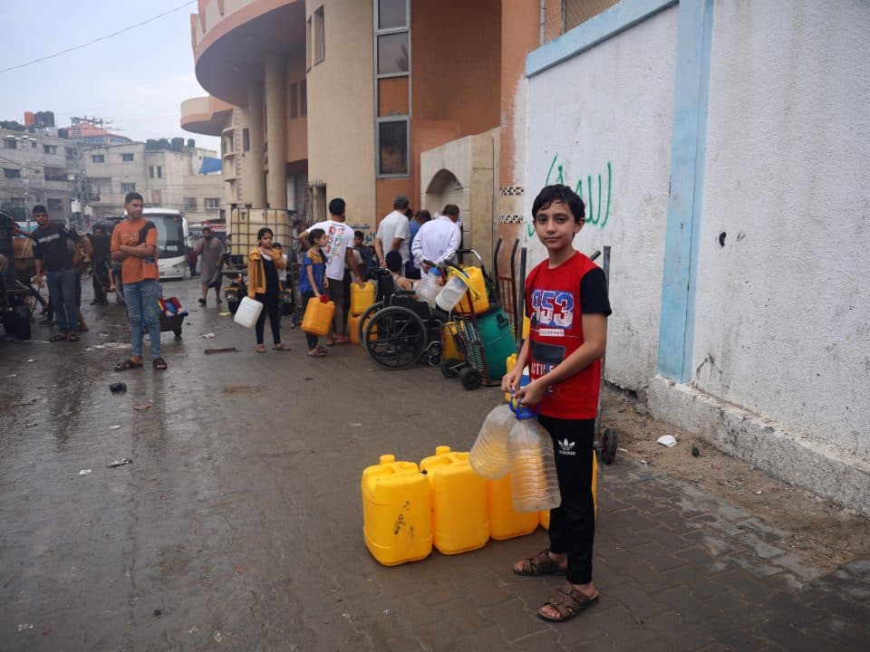 Ahmad, 14 ans, pose pour une photo alors qu'il attend à la ligne d'eau potable dans la ville de Rafah. Ahmad a évacué sa maison à Jabalia il y a 17 jours pour se mettre à l'abri des bombardements. © UNICEF/UNI463721/El Baba