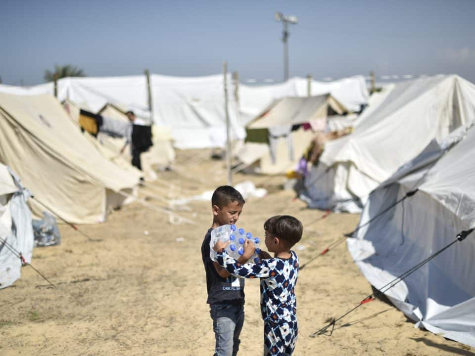 Yamen, 7 ans, et son frère Yazan, 4 ans, transportant des bouteilles d'eau distribuées par l'UNICEF dans le camp de réfugiés de l'UNRWA à Khan Yunis, au sud de la bande de Gaza. © UNICEF/UNI472261/Zaqout