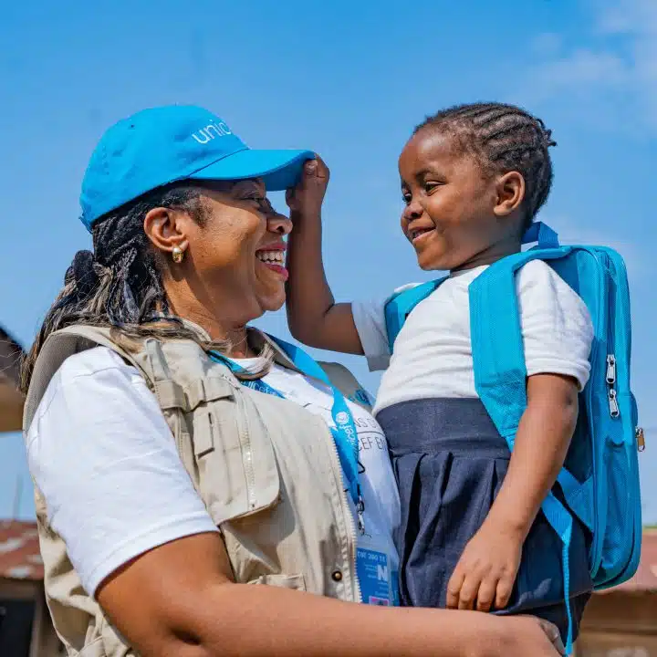 Le 12 octobre 2023, en RDC, Nkembo, 7 ans, joue avec Solange Nabintu Murhega, membre du personnel de l'UNICEF à Kinshasa. La petite fille vient de recevoir un kit scolaire de l'UNICEF. © UNICEF/UNI456462/Mulala