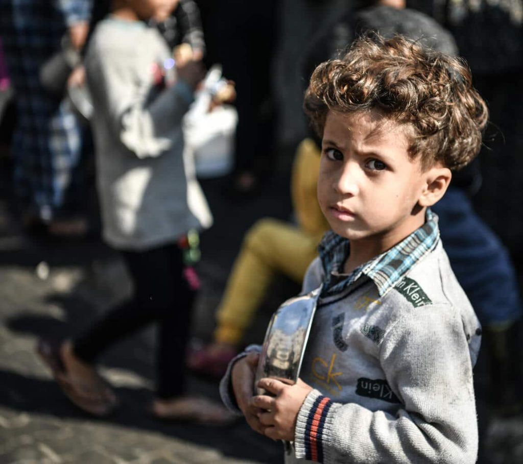 Ahmad, 5 ans, attend son tour dans la foule pour recevoir un repas d'un centre caritatif qui distribue de la nourriture gratuitement dans la ville de Rafah, au sud de la bande de Gaza. © UNICEF/UNI495575/ZAGOUT