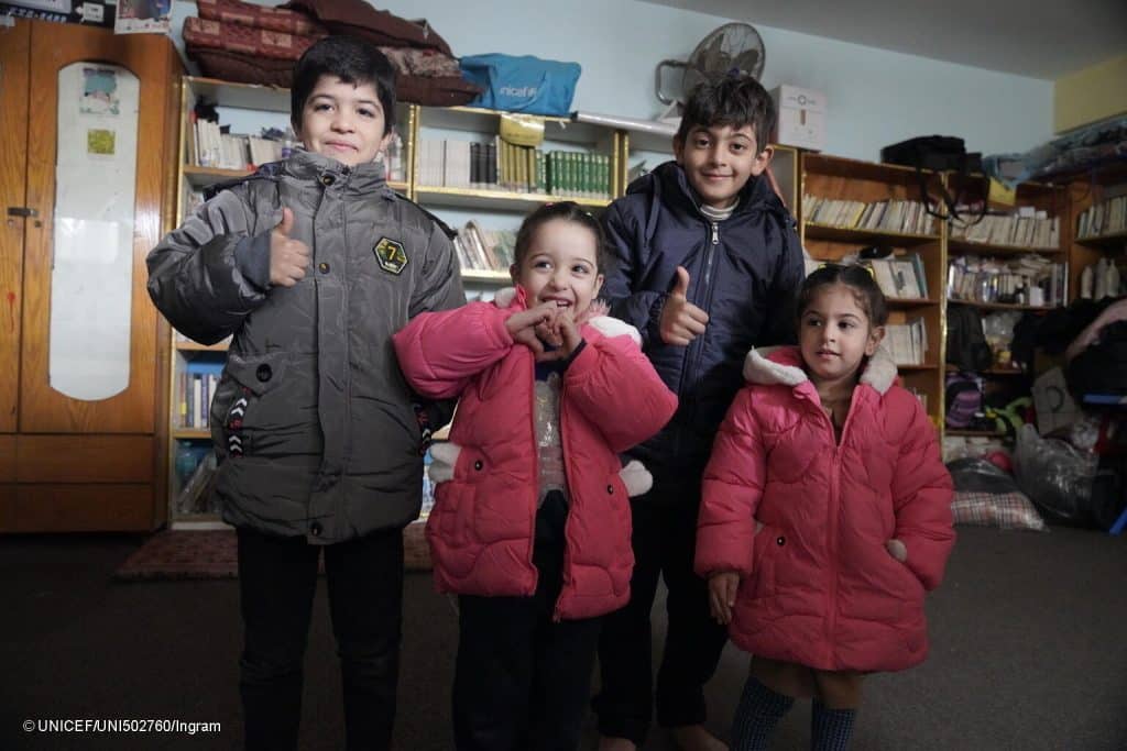 Le 13 janvier 2024, des enfants posent pour une photo au Centre des femmes de Rafah, dans le sud de Gaza, actuellement utilisé comme abri, après la distribution de manteaux d'hiver, achetés par l'UNICEF et distribués par ses partenaires. © UNICEF/UNI502760/Ingram