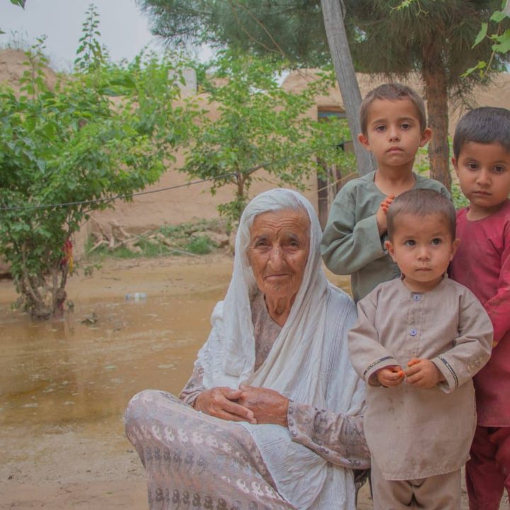 Le 16 mai 2024, Bigom, et ses trois petits-fils après les inondations soudaines dans son village, en Afghanistan. © UNICEF/UNI577384/Khayyam
