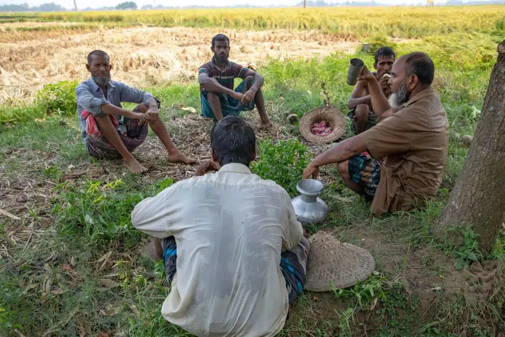Au Bangladesh, des agriculteurs se reposent et boivent de l'eau pendant la vague de chaleur nationale. © UNICEF/UNI579529/Paulash