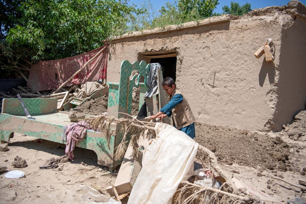 Le 3 juin 2024, Hassan, 12 ans, se tient devant sa maison détruite par les inondations qui ont touché son village dans la province de Baghlan, au nord de l'Afghanistan.© UNICEF/UNI585908/Musadiq