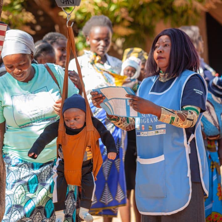 Le 19 juin 2024 en Zambie, un enfant est pesé dans le cadre d'un dépistage de la malnutrition dans la province du Sud, lors d'une visite d'une délégation de l'UNICEF © UNICEF/UNI597100/Sampa