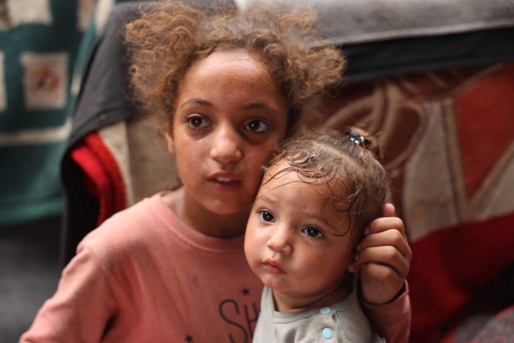 Rama, 11 ans, et sa sœur Malak, 1 an, sont réfugiées dans une tente à Deir al-Balah, dans la bande de Gaza.© UNICEF/UNI589857/El Baba