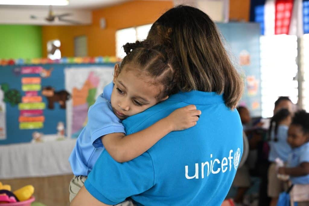 Un membre du personnel de l'UNICEF est avec un enfant dans une école maternelle à Belize City, la plus grande ville du Belize. © UNICEF/UNI594328/Dejongh