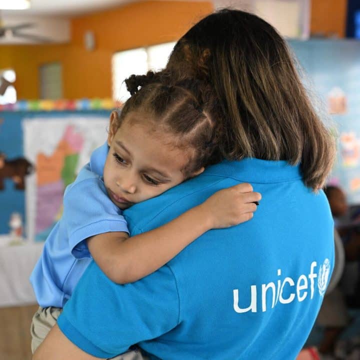 Un membre du personnel de l'UNICEF est avec un enfant dans une école maternelle à Belize City, la plus grande ville du Belize. © UNICEF/UNI594328/Dejongh