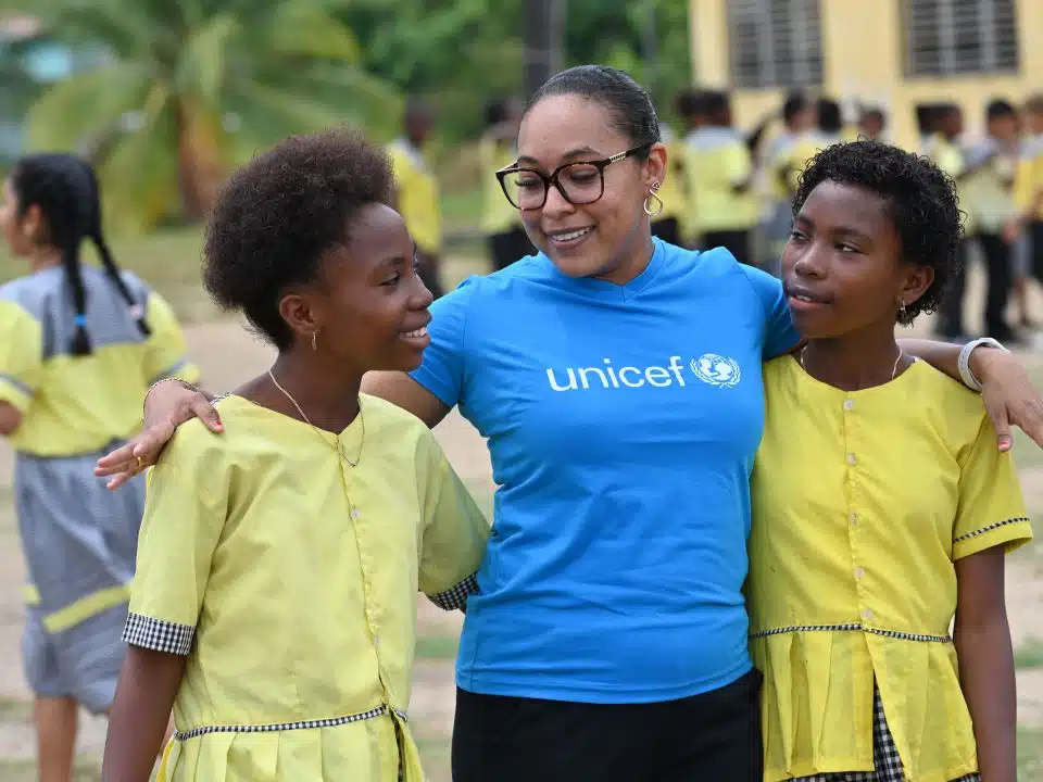 Un membre du personnel de l'UNICEF discute avec des filles de l'école primaire Gulisi de Dangriga, dans le sud du Belize. L'UNICEF a travaillé avec cette école pour soutenir l'éducation bilingue des enfants. © UNICEF/UNI594407/Dejongh