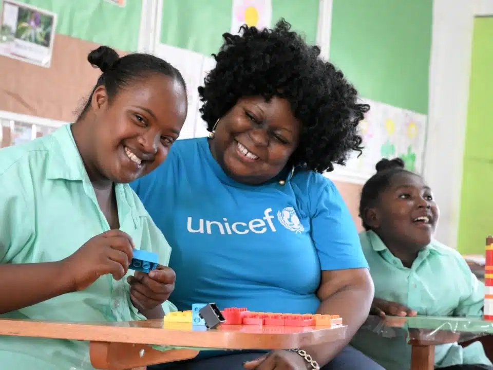 Phyllis, une jeune fille de 16 ans, est avec un membre du personnel de l'UNICEF, à l'école primaire Stella Maris de Belize City, la plus grande ville du Belize. Cette école accueille des enfants handicapés. L'UNICEF a apporté son soutien à la mise en place d'un programme spécial visant à enseigner aux élèves les compétences nécessaires à l'apprentissage d'un métier. © UNICEF/UNI596007/Dejongh